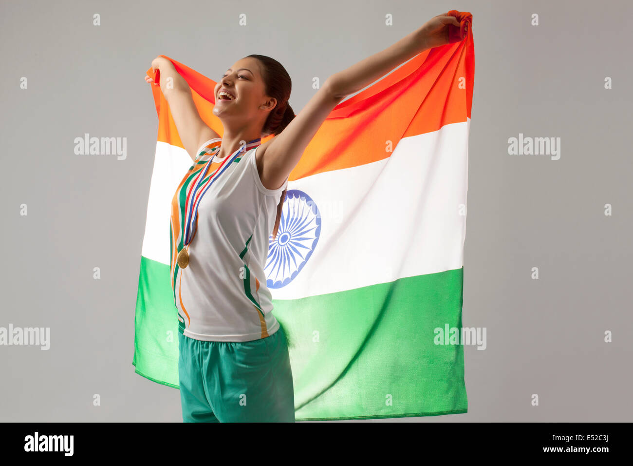 Jeune femme célèbre médaillé de la victoire avec drapeau indien isolé sur fond gris Banque D'Images
