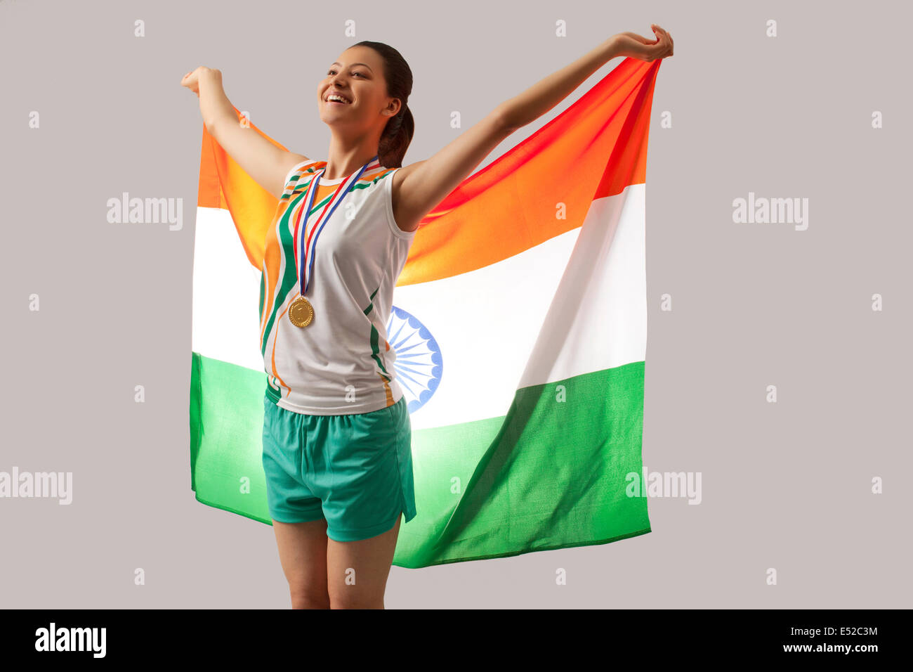 Célébrer la victoire avec le médaillé d femelle drapeau indien isolé sur fond gris Banque D'Images