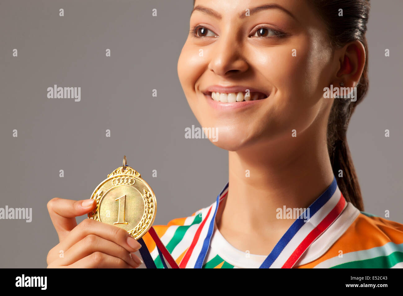 Close-up of young woman holding médaille d'isolé sur fond gris Banque D'Images