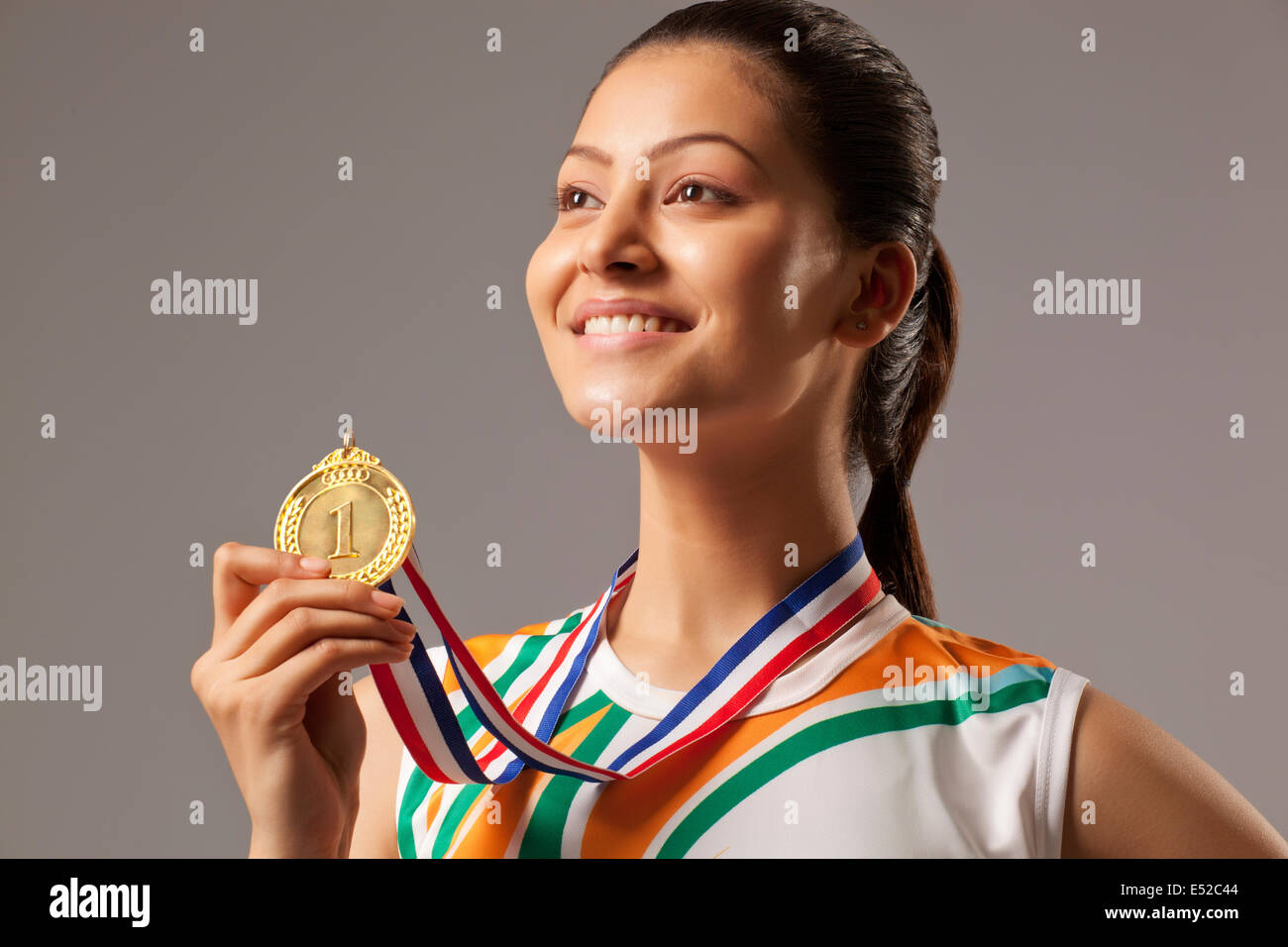 Close-up of woman holding médaille d'isolé sur fond gris Banque D'Images