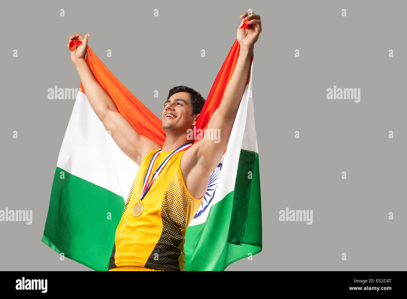Heureux de célébrer la victoire avec le médaillé d'hommes drapeau indien contre l'arrière-plan gris Banque D'Images