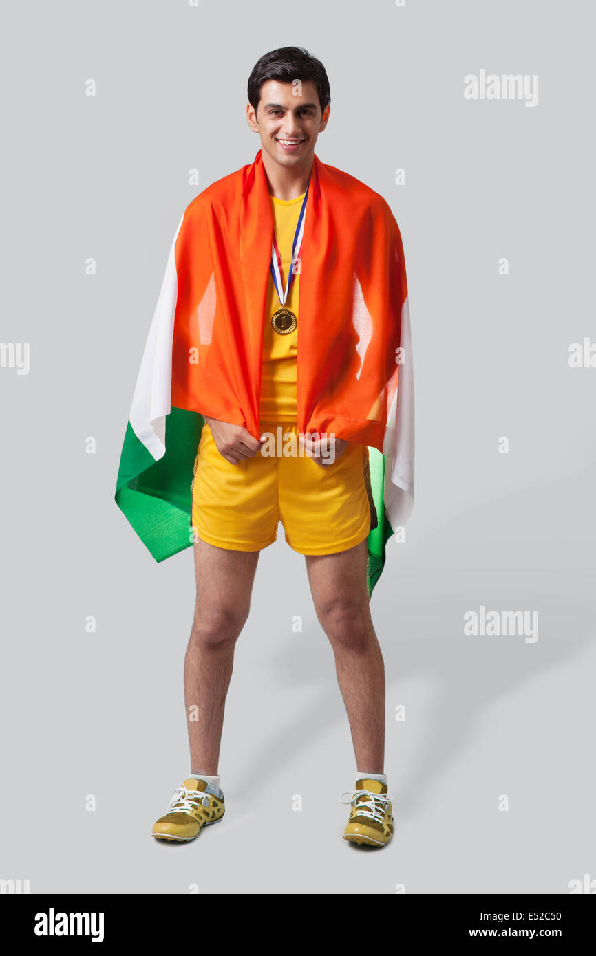 Portrait de jeune homme célèbre médaillé la victoire avec drapeau indien isolé sur fond gris Banque D'Images