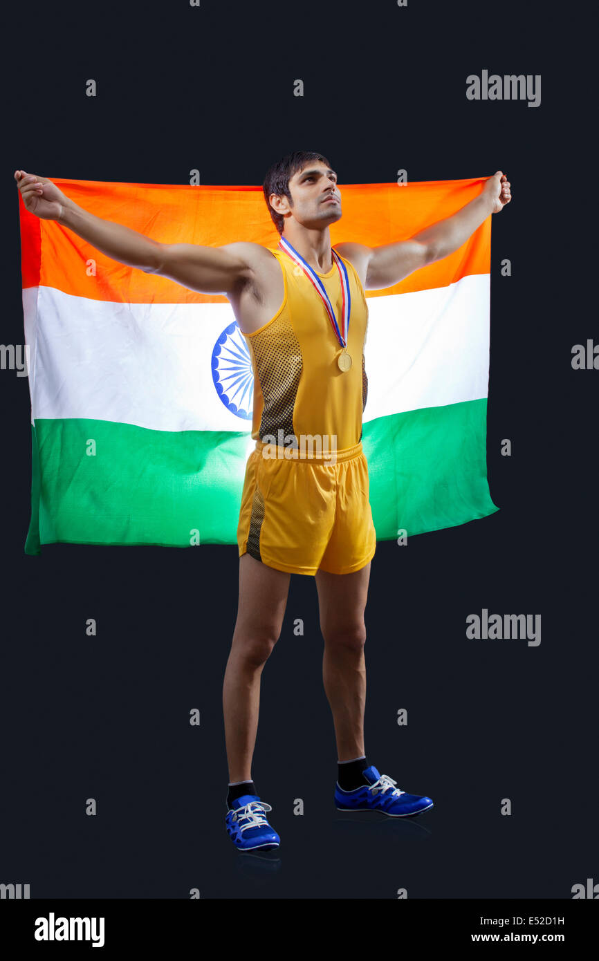 Toute la longueur de l'homme d'or avec drapeau indien à la recherche sur fond noir Banque D'Images