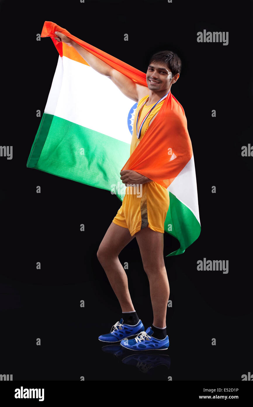 Portrait de l'homme heureux avec drapeau indien médaillé sur fond noir Banque D'Images