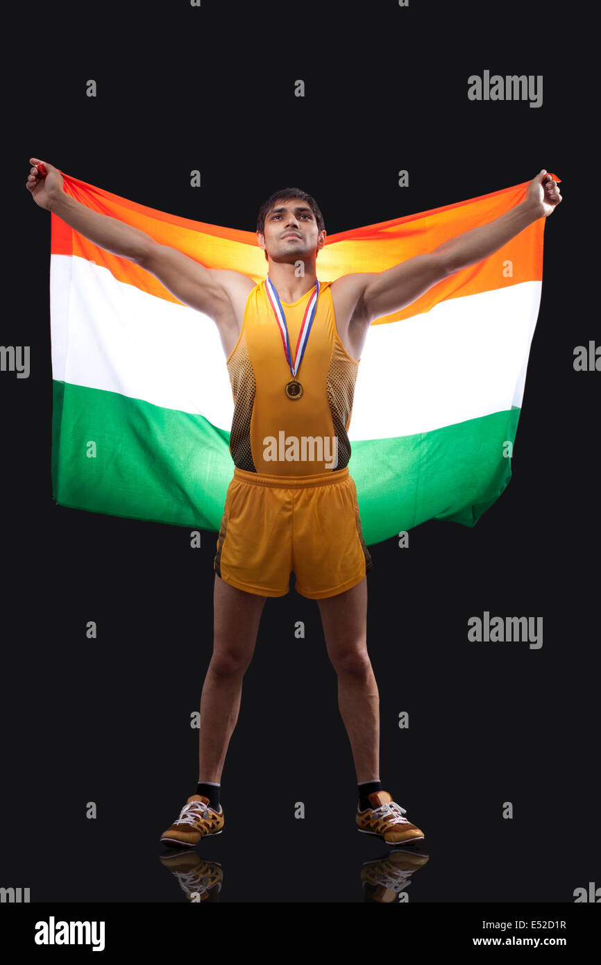 Fier jeune médaillé olympique avec drapeau indien sur fond noir permanent Banque D'Images