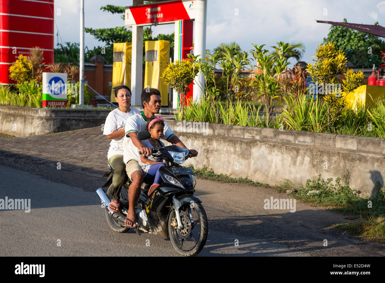 Bali, Indonésie. Famille sur moto, pas de casques. Banque D'Images