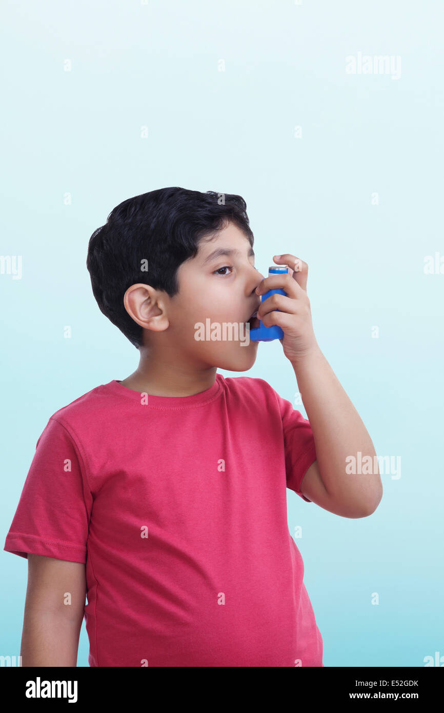 Garçon asthmatique à l'aide d'un inhalateur Banque D'Images