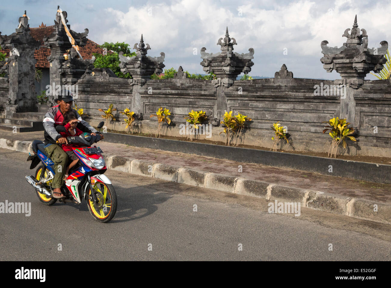 Bali, Indonésie. Père et fille sur moto, pas de casques. Banque D'Images