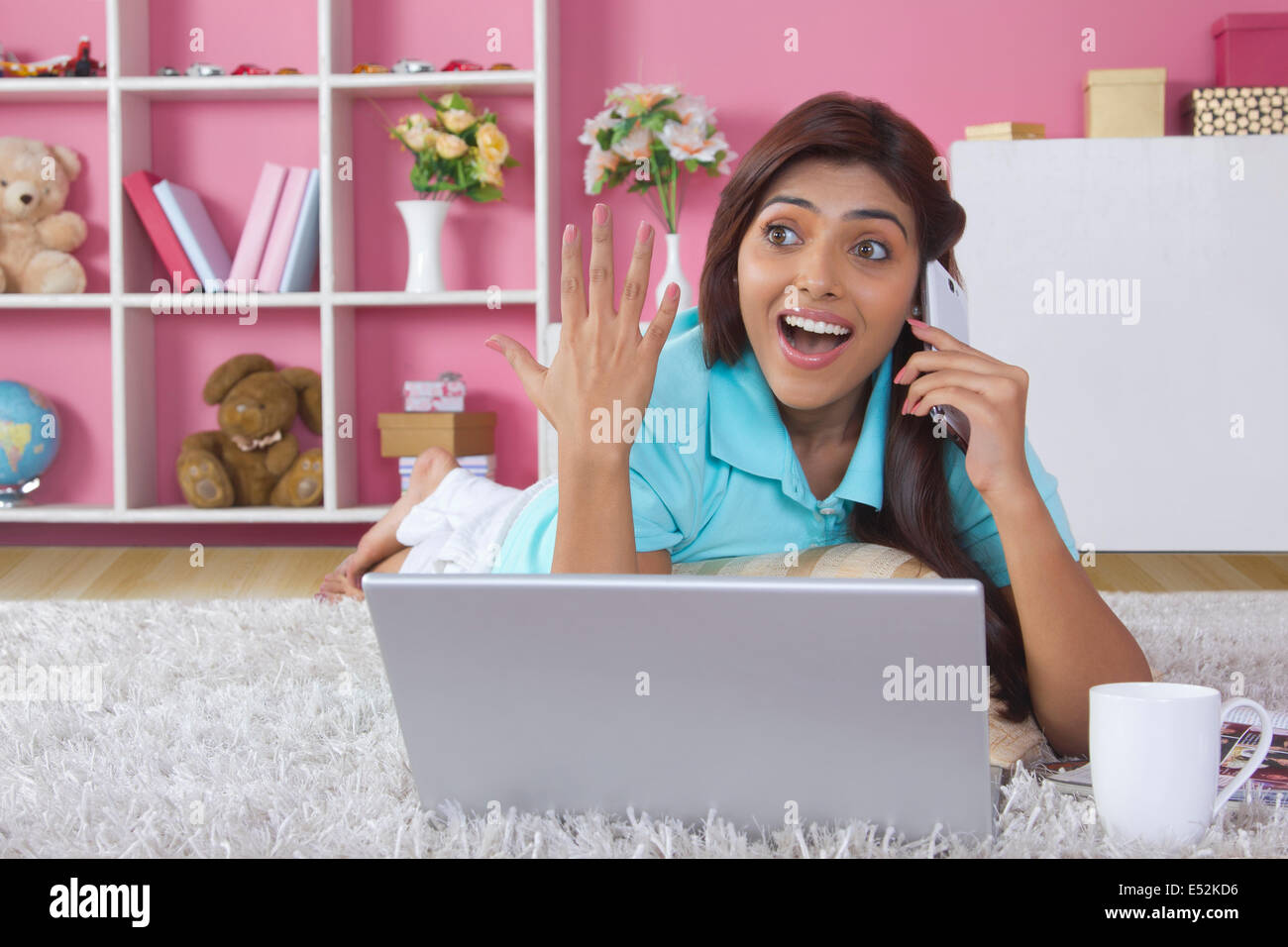 Surpris femme répondant au téléphone mobile home Banque D'Images