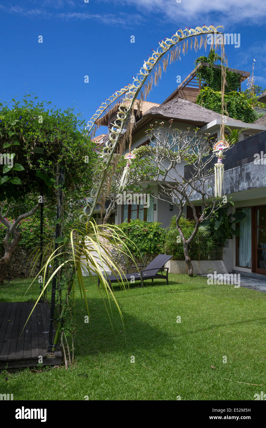 Bali, Indonésie. Un Penjor de bambou et de palmier décore un immeuble d'arrière-cour en l'honneur de la fête de Galungan. Banque D'Images