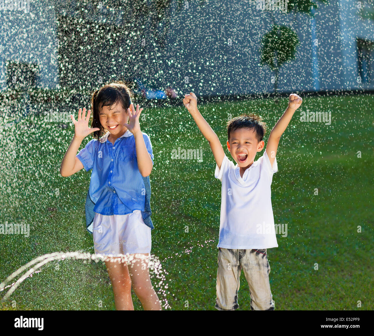 Les enfants excités a plaisir à jouer dans l'eau Fontaine Banque D'Images