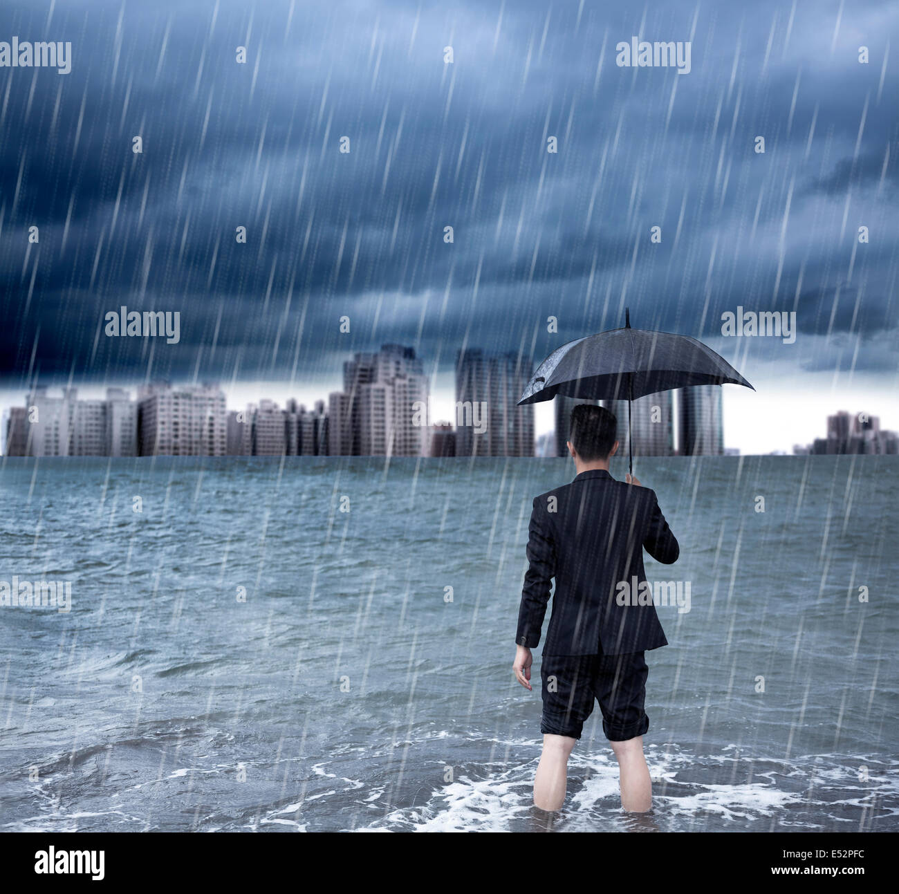 Business man holding an umbrella et debout avec trombe d'arrière-plan Banque D'Images