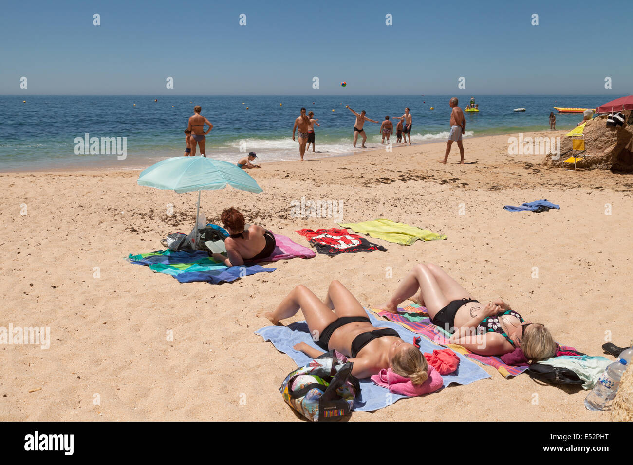 Les gens à prendre le soleil sur des vacances sur la plage de Vale Centeanes, Algarve, Portugal Europe Banque D'Images