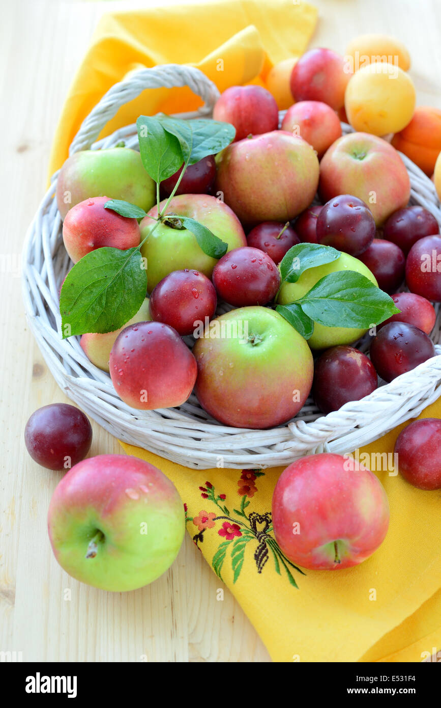 Fruits frais avec des feuilles dans le panier. Banque D'Images