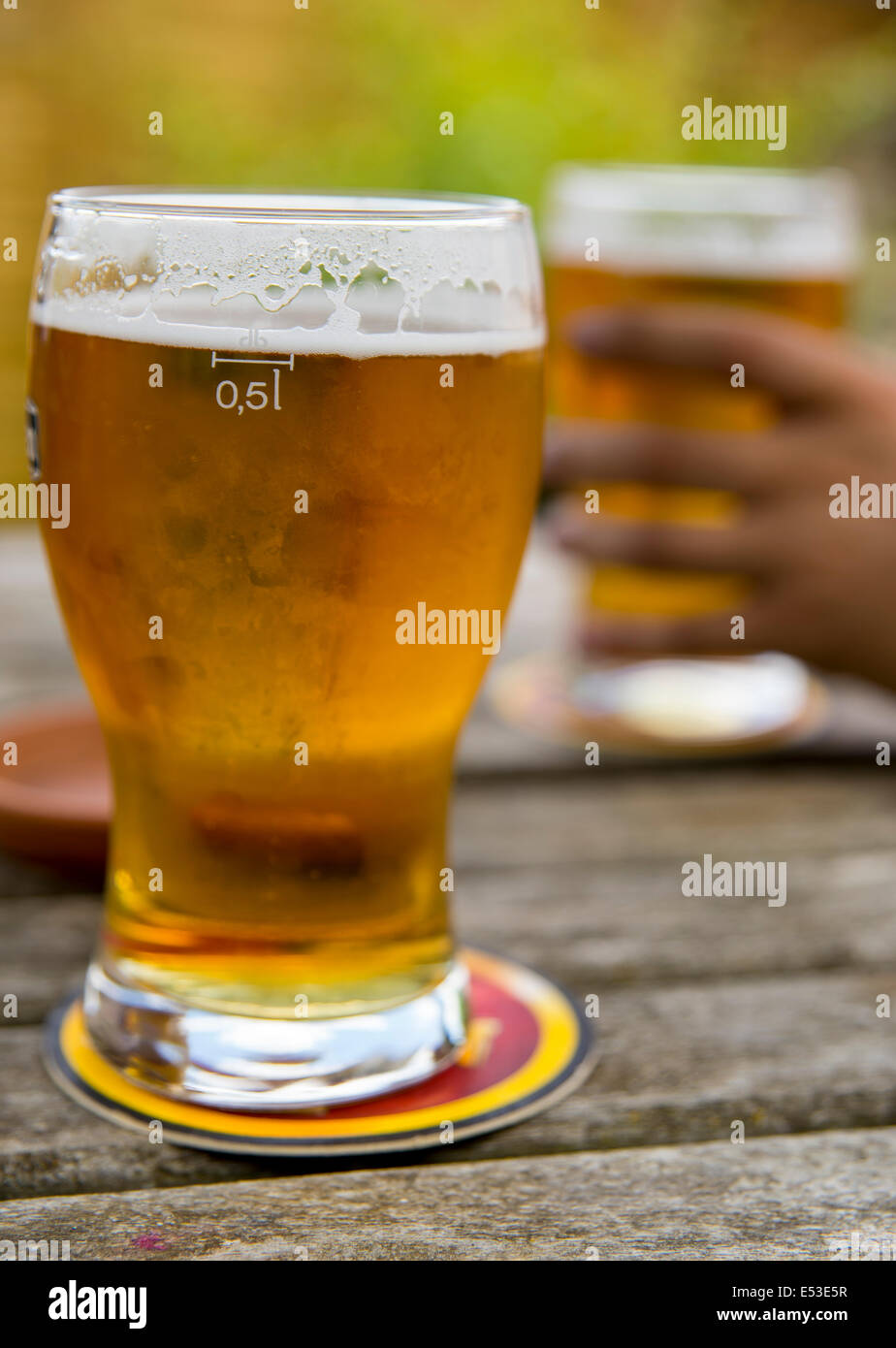 Les pintes de bière blonde s'assit sur une table de pub Banque D'Images