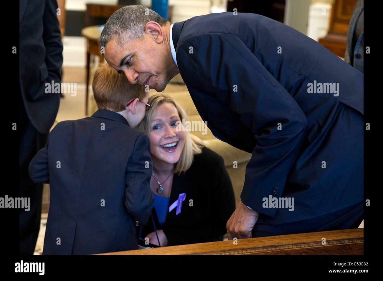 Le président américain Barack Obama eavesdrops comme Aidan Lamothe, la Marche des dix sous 2014 Ambassadeur, whispers to sa mère qu'il avait souhaité voir le président et Bo, le chien de la famille Obama, lors de sa visite dans le bureau ovale le 1 mai 2014 à Washington, DC. Banque D'Images