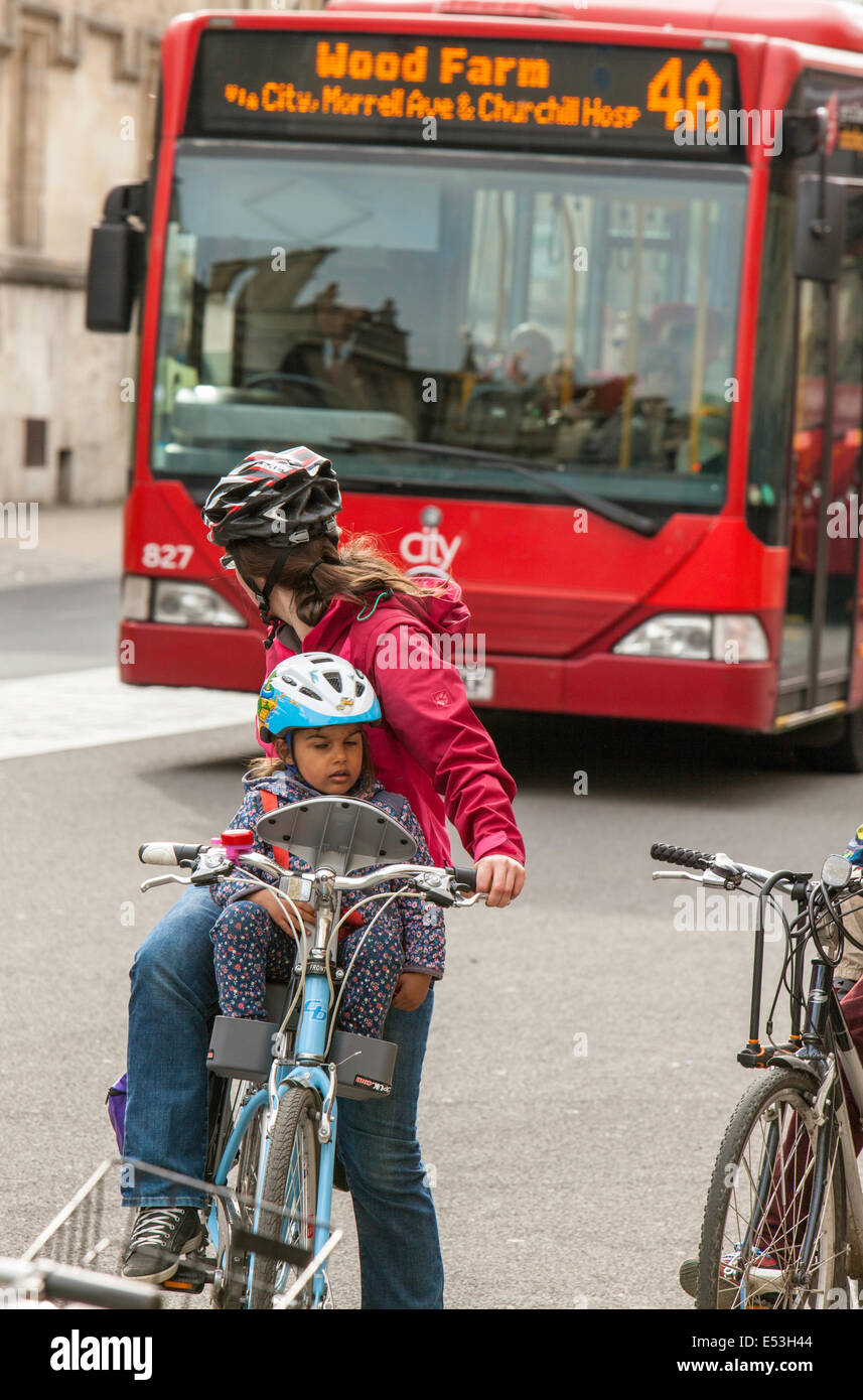 Jeune Mère avec enfant en attente alors qu'un bus passe par avant déménagement, Oxford, England, UK Banque D'Images