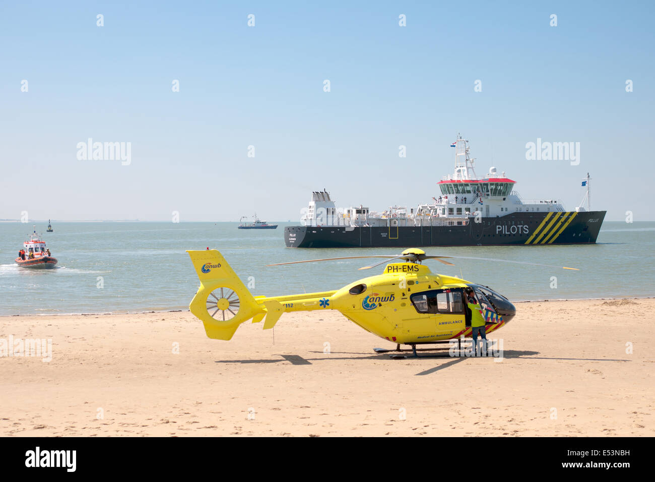 Hélicoptère de sauvetage est sur la plage de Vlissingen avec un bateau-pilote à l'arrière-plan de sauvetage au cours de Vlissingen. Banque D'Images