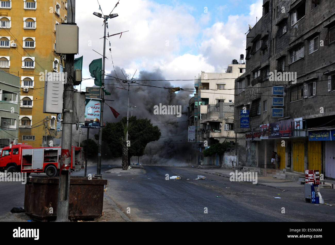 La ville de Gaza, bande de Gaza, Cisjordanie. 18 juillet, 2014. La fumée est vu passant d'un bâtiment après qu'il a été touché par un missile israélien à Gaza. Les troupes israéliennes à Gaza s'enfonce encore plus le vendredi pour détruire des sites de lancement de roquettes et des tunnels, en tirant des rafales d'obus et des affrontements avec des combattants palestiniens dans une offensive terrestre destiné à affaiblir le Hamas de l'enclave, dirigeants. © Mohammed Talatene Images/APA/ZUMA/Alamy Fil Live News Banque D'Images