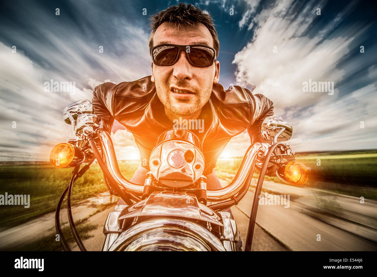 Funny Biker veste en cuir et lunettes de course sur la route avec le soleil en arrière-plan Banque D'Images