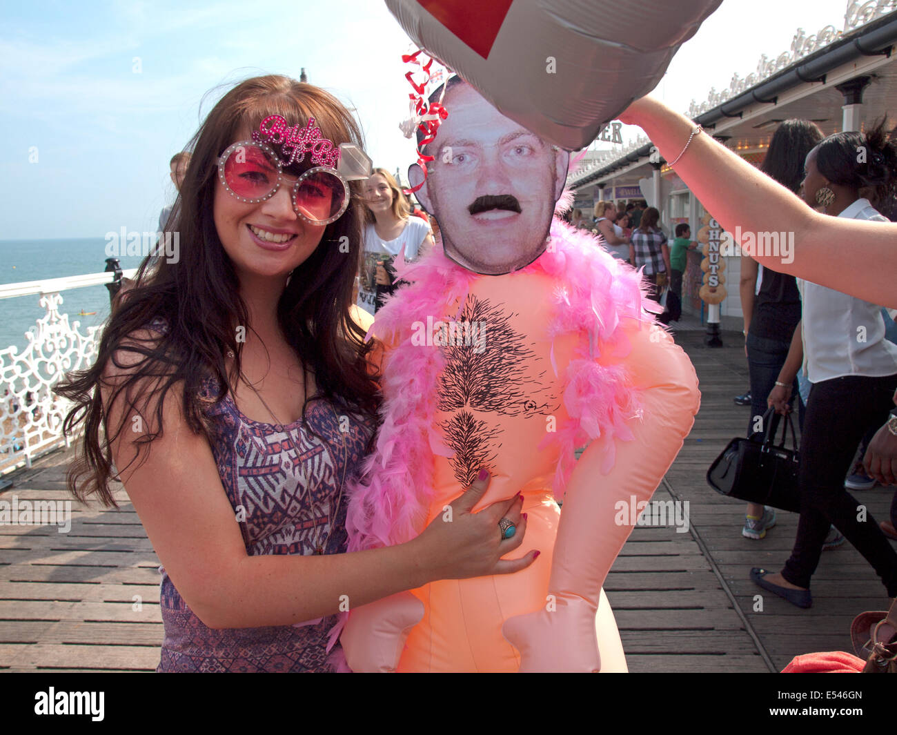 Une future mariée est titulaire d'une effigie de son futur mari sur la jetée de Brighton Banque D'Images