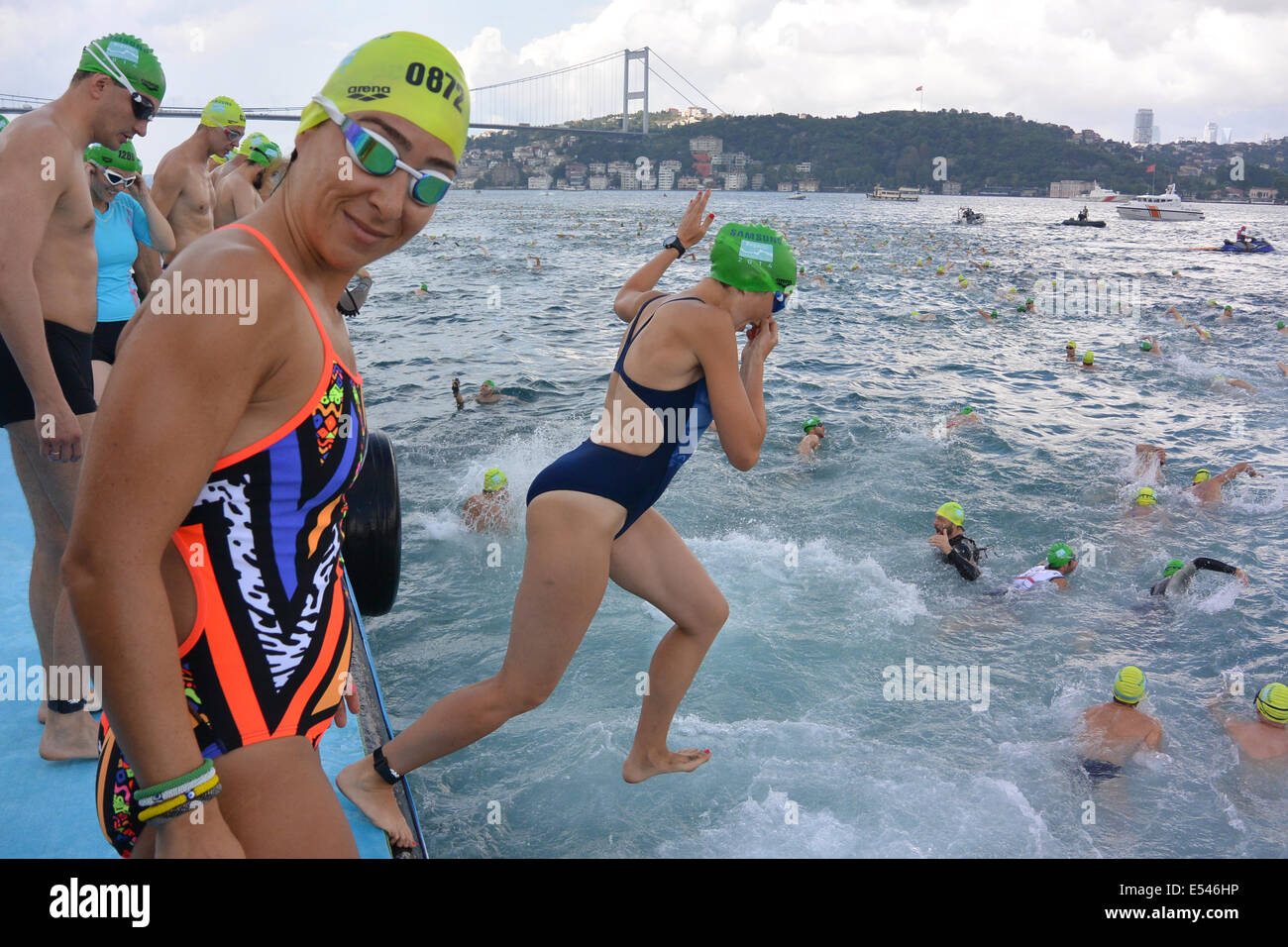 Istanbul, Turquie. 20 juillet 2014. Nageurs au début de la course du Bosphore, dans laquelle les concurrents nagent de l'Asie à l'Europe à travers la course du Bosphore. En arrière-plan le deuxième pont reliant l'Europe et l'Asie, le pont Fatih Sultan Mehmet, peut être vu, la course se termine à 6,5 km en aval juste avant le premier pont qui relie l'Europe et Aisa. Crédit : Susanne Masters/Alamy Live News Banque D'Images