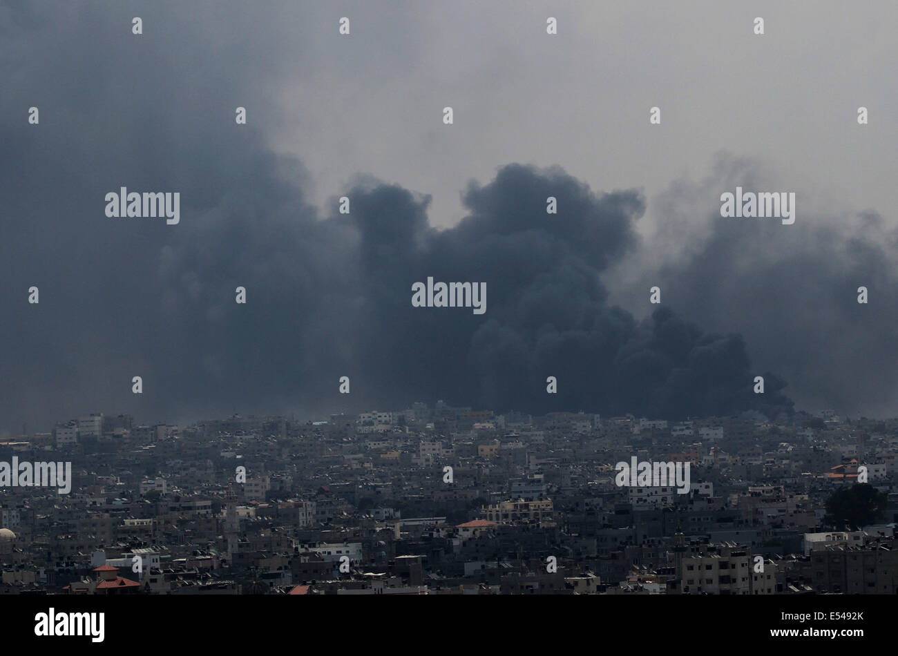 Gaza, Territoires palestiniens. 20 juillet, 2014. La fumée monte après les bombardements à Al Shejaiyaa dans le quartier est de la ville de Gaza le long de la frontière entre Israël et Gaza, le 20 juillet 2014. Des dizaines de milliers de Palestiniens vivant dans la région qui est à proximité de leurs maisons de gauche au cours des jours à chercher l'abri d'une invasion terrestre israélienne. Israël a été appuyé sur son opération terrestre dans le sud de Gaza, après l'infanterie entré l'enclave côtière il y a trois jours pour mettre fin à la roquette et détruire les tunnels menant au crédit d'Israël : ZUMA Press, Inc./Alamy Live N Banque D'Images