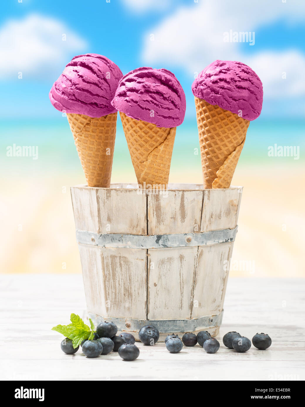 Trois glaces dans la benne rustique avec des bleuets et de la plage arrière-plan flou Banque D'Images