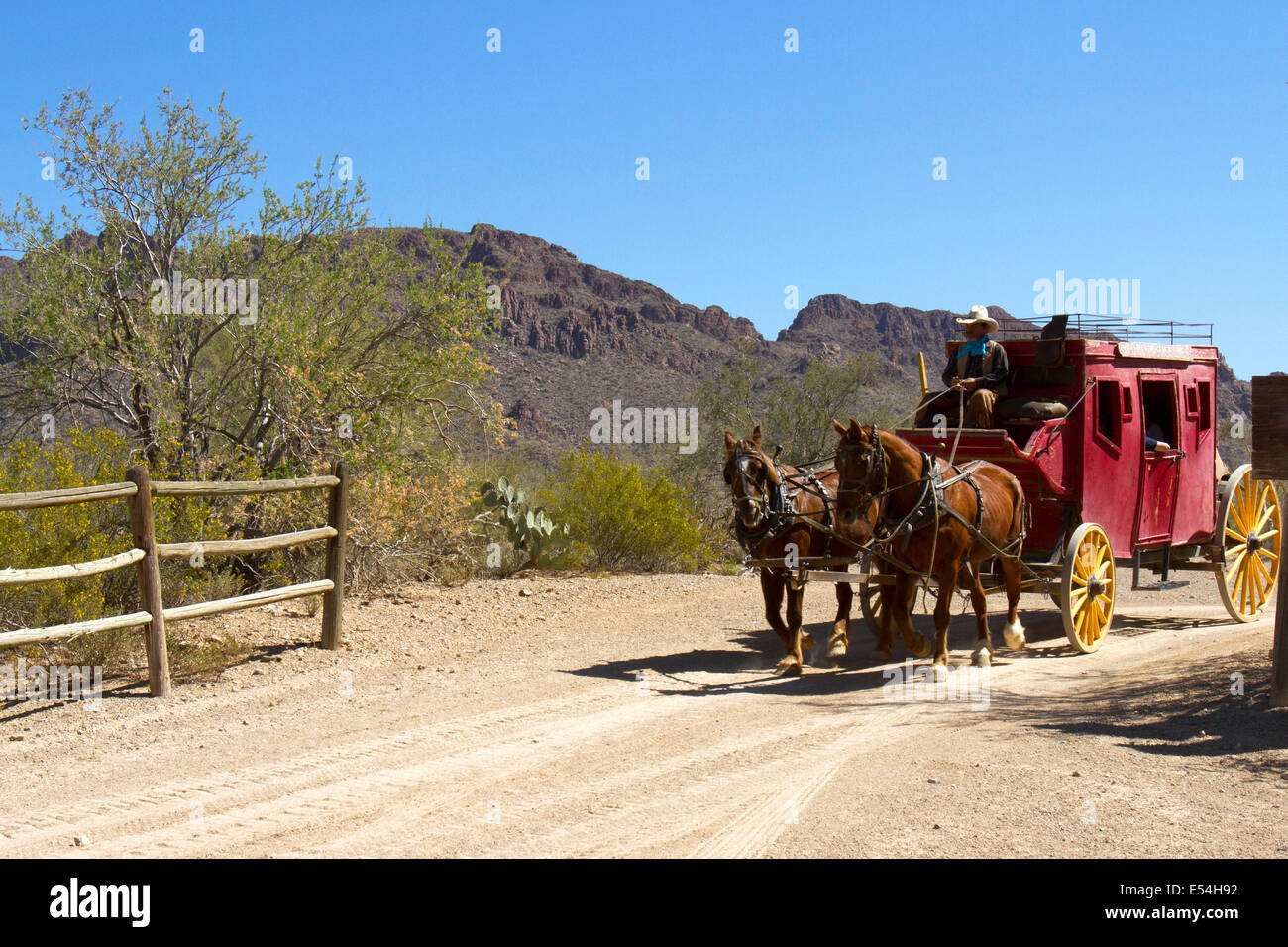 Attelage de chevaux tirant stage coach à travers désert dans sud-ouest américain Banque D'Images