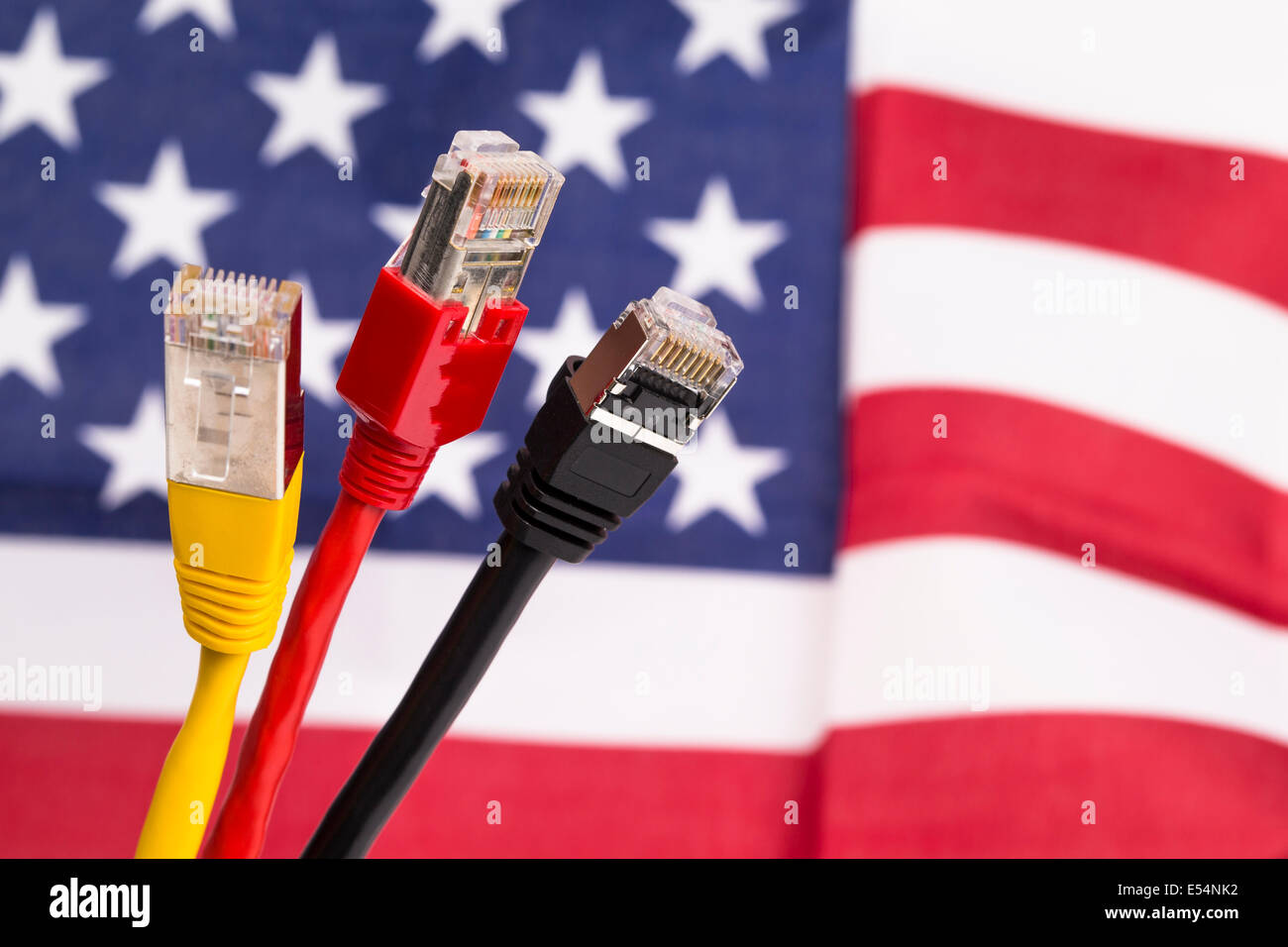 Image montre trois câbles réseau couleur en noir, rouge, jaune en face d'un drapeau américain Banque D'Images