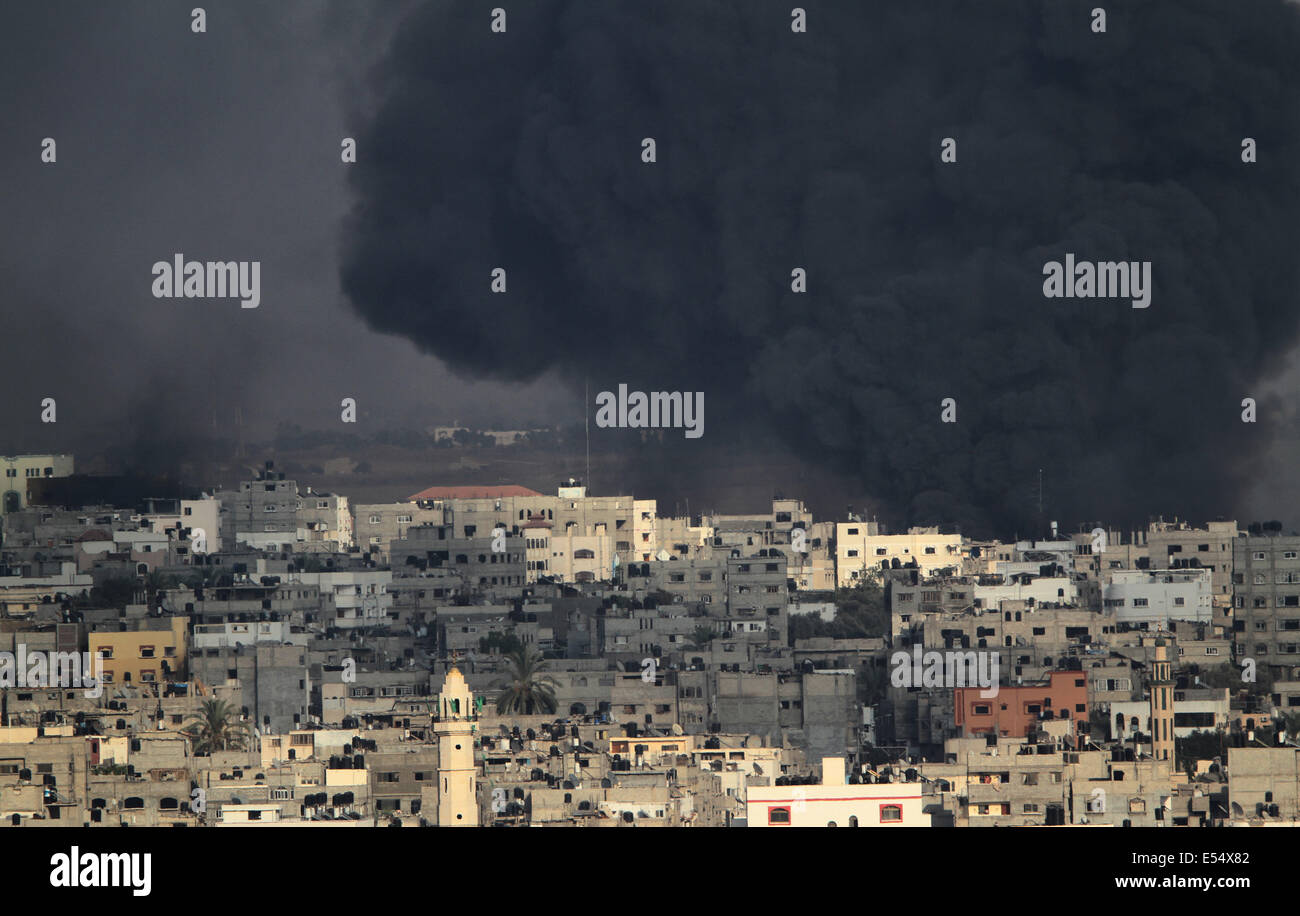 La bande de Gaza. 21 juillet, 2014. La fumée monte après les bombardements à Al Shejaiyaa dans le quartier est de la ville de Gaza le long de la frontière entre Israël et Gaza, le 20 juillet 2014. Des dizaines de milliers de Palestiniens vivant dans la région qui est à proximité de leurs maisons de gauche au cours des jours à chercher l'abri d'une invasion terrestre israélienne. Israël a été appuyé sur son opération terrestre dans le sud de Gaza, après l'infanterie entré l'enclave côtière il y a trois jours pour mettre fin à la roquette et détruire les tunnels menant vers Israël, selon l'armée. Credit : ZUMA Press, Inc./Alamy Live News Banque D'Images