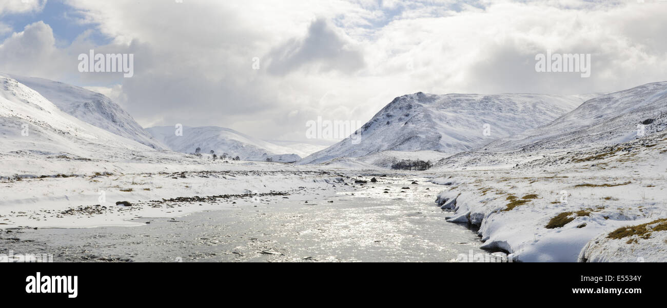 Vue le long de l'eau dans Glen Clunie, Clunie à au sud en direction de Creag nan Gabhar (gauche) et une Mhadaidh Creag' (à droite), avec de la neige profonde situées sur des collines, N.P. Cairngorms, l'Aberdeenshire, Ecosse, Highlands, Mars Banque D'Images