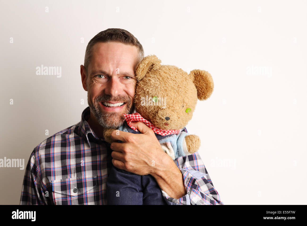 Man smiling and holding a teddy bear Banque D'Images
