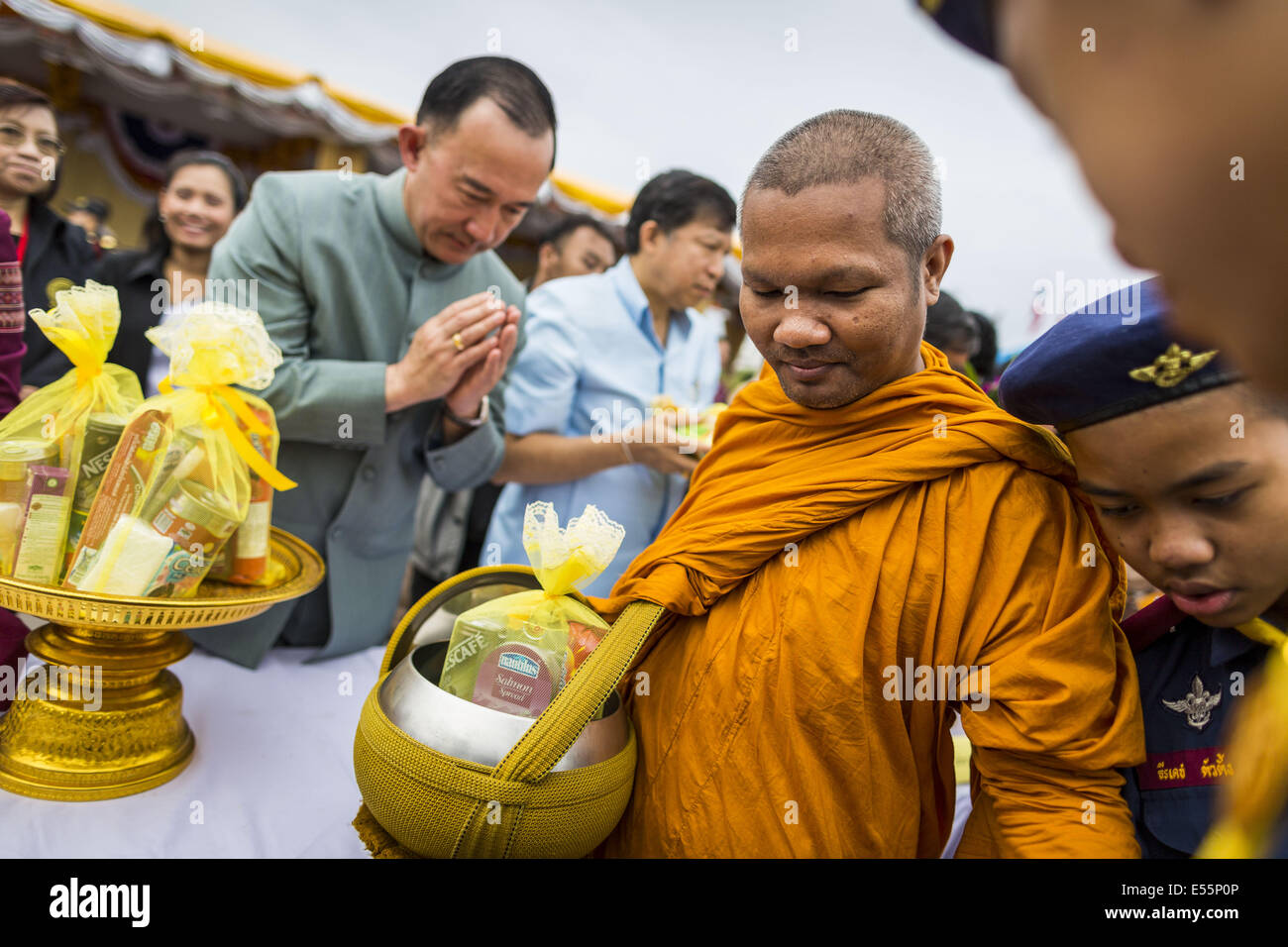 Bangkok, Thaïlande. 22 juillet, 2014.Un homme fait mérite en présentant l'aumône à un moine bouddhiste au cours d'une cérémonie qui mérite à Sanam Luang. Des centaines de militaires thaïlandais officiers et fonctionnaires ont assisté à un service de chants bouddhistes et le mérite de faire de la cérémonie pour marquer le 2ème mois anniversaire du 22 mai coup d'État qui a déposé le gouvernement civil élu et s'est terminé près de six mois, parfois violents, des manifestations anti-gouvernementales. Credit : ZUMA Press, Inc./Alamy Live News Banque D'Images