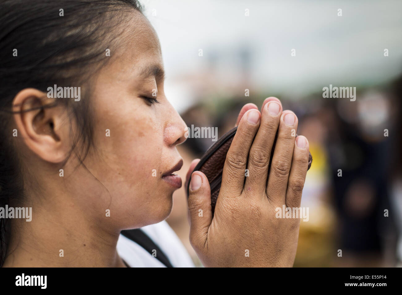 Bangkok, Thaïlande. 22 juillet, 2014.Une femme thaïlandaise prie lors d'une cérémonie qui mérite à Sanam Luang. Des centaines de militaires thaïlandais officiers et fonctionnaires ont assisté à un service de chants bouddhistes et le mérite de faire de la cérémonie pour marquer le 2ème mois anniversaire du 22 mai coup d'État qui a déposé le gouvernement civil élu et s'est terminé près de six mois, parfois violents, des manifestations anti-gouvernementales. Credit : ZUMA Press, Inc./Alamy Live News Banque D'Images