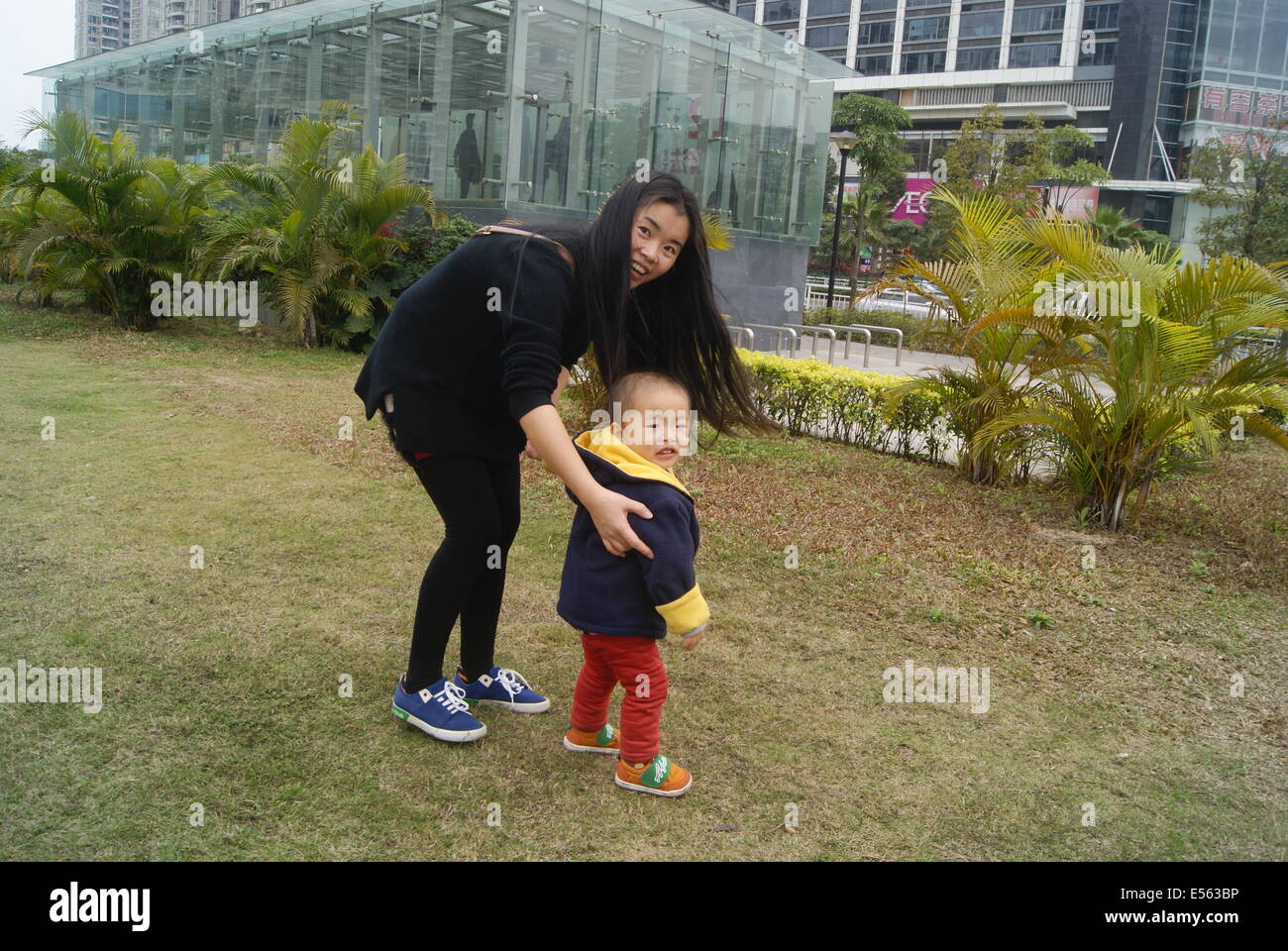 Une jeune mère chinoise avec son fils jouant dans le parc. Banque D'Images