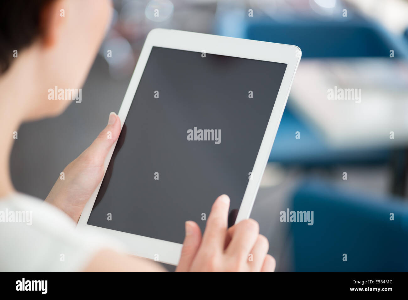 Woman holding et touchant sur une tablette numérique moderne et à la recherche sur un écran vierge. Banque D'Images