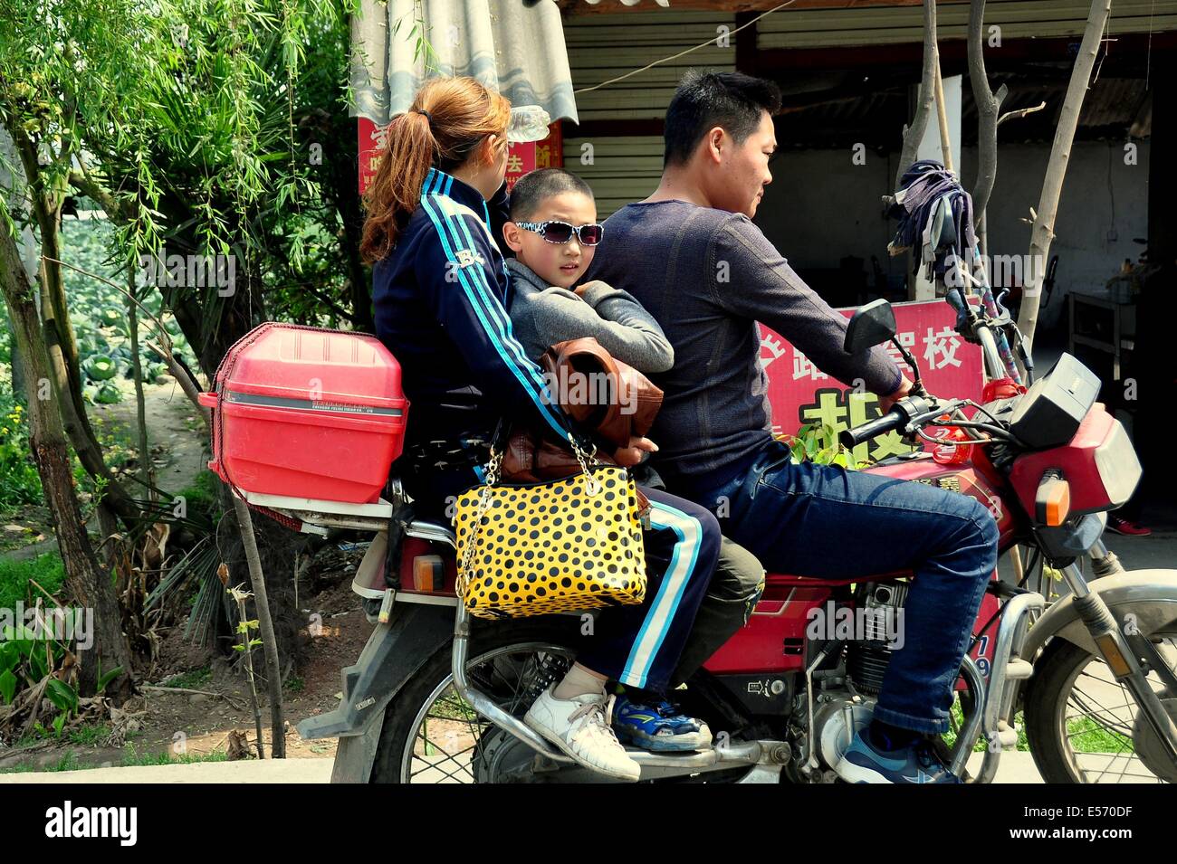 JIA WAN (Sichuan), Chine : mère, père, et son jeune fils portant des lunettes de sport moto sur la famille Banque D'Images