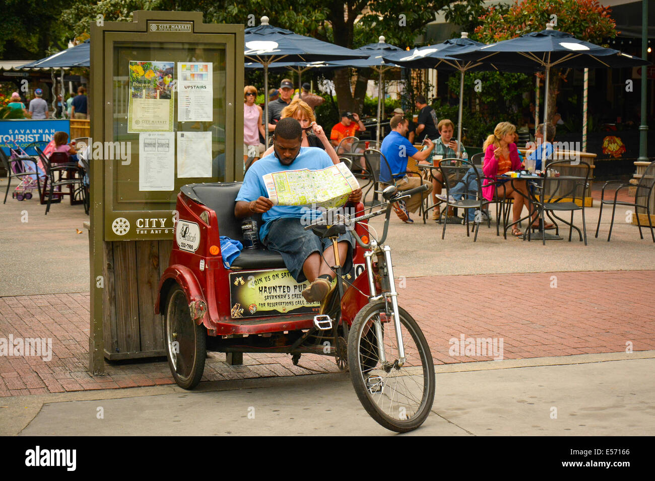 Savannah Pedicab driver prend une pause pour étudier une carte à l'populaires Ellis Square, Savannah, GA, États-Unis d'Amérique Banque D'Images