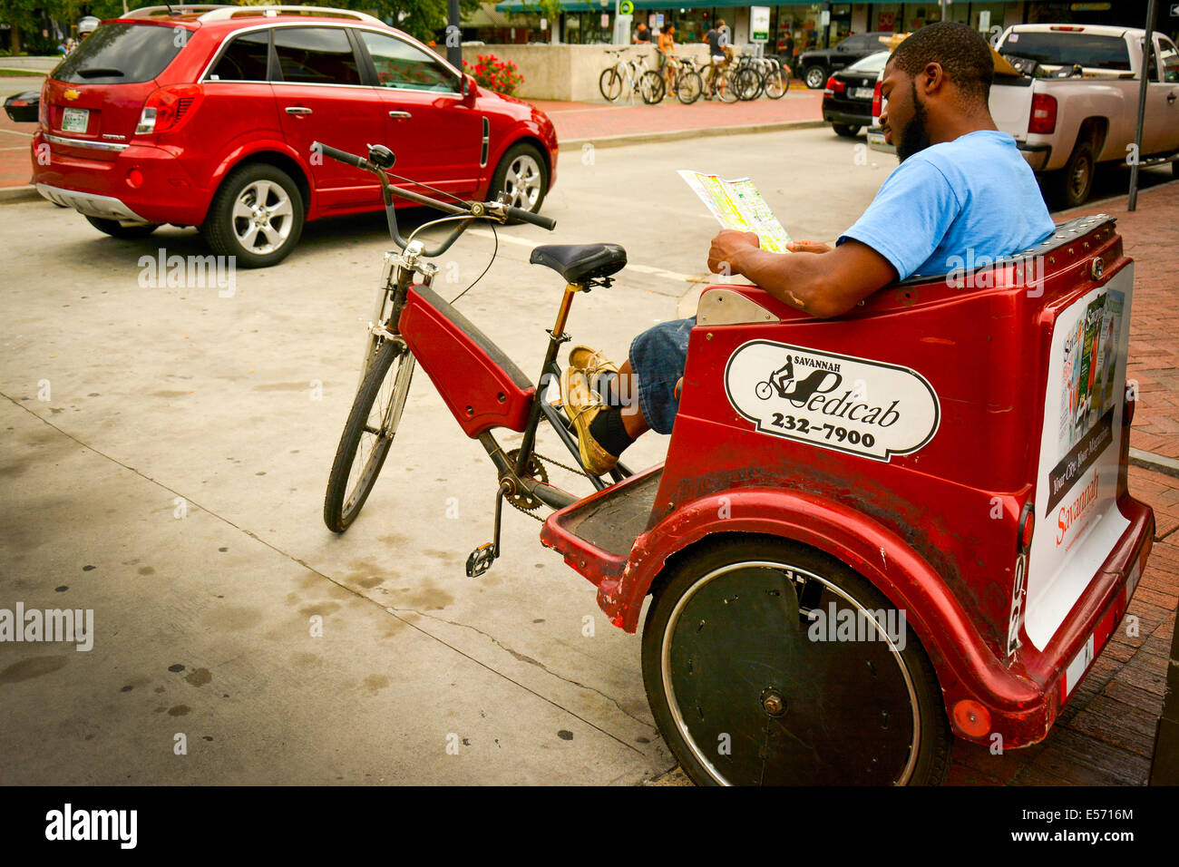 Savannah Pedicab driver prend une pause pour étudier une carte à l'populaires Ellis Square, Savannah, GA, États-Unis d'Amérique Banque D'Images