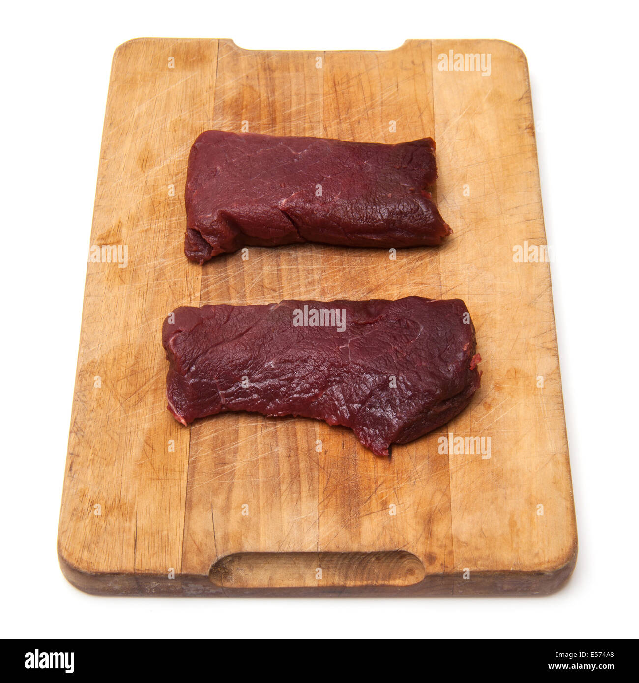 La viande de chameau steaks sur une planche à découper en bois isolé sur un fond blanc studio. Banque D'Images