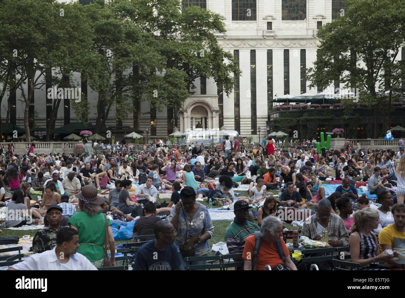 Des foules de gens se détendre sur la pelouse au Bryant Park en attente pour regarder un film gratuit le soir pendant son festival du film d'été à NEW YORK Banque D'Images