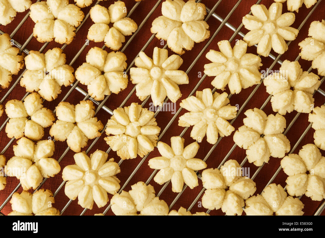 En forme de fleur fait maison appuyez sur les cookies sur une grille de refroidissement Banque D'Images