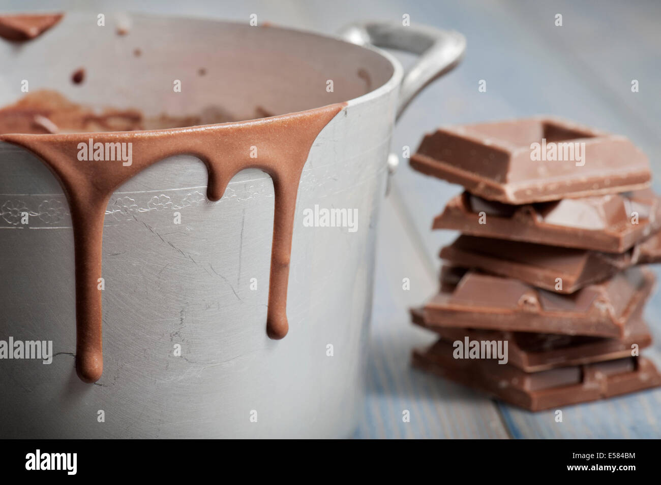 Pan de terre chaude avec des gouttes de chocolat fondu et blocs de chocolat, on wooden table Banque D'Images