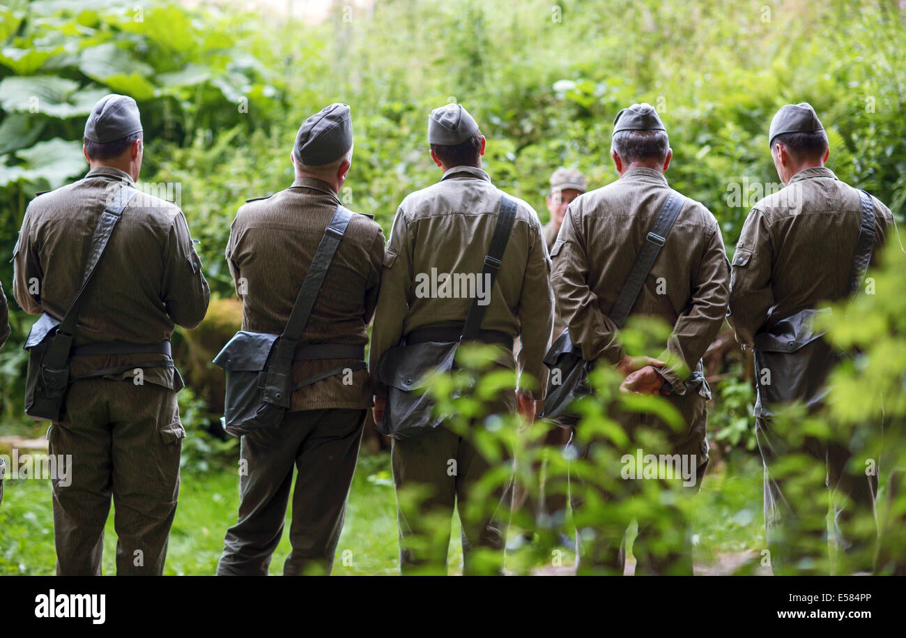 Les visiteurs portent des uniformes de l'armée du peuple (NPA) de la République démocratique allemande (RDA) au cours de la reconstitution d'un exercice militaire au Musée du Bunker à Neustadt Am Rennsteig Frauenwald, Allemagne, 19 juillet 2014. Le musée privé propose un voyage dans le temps y compris une nuitée dans l'ancien complexe de bunker de la RDA's Ministère de la sécurité d'État (Stasi). Le bunker est complexe 3 600 mètres carrés et était censé permettre à la commande district Suhl pour continuer à fonctionner en cas de guerre. Photo : Michael Reichel /ZB Banque D'Images