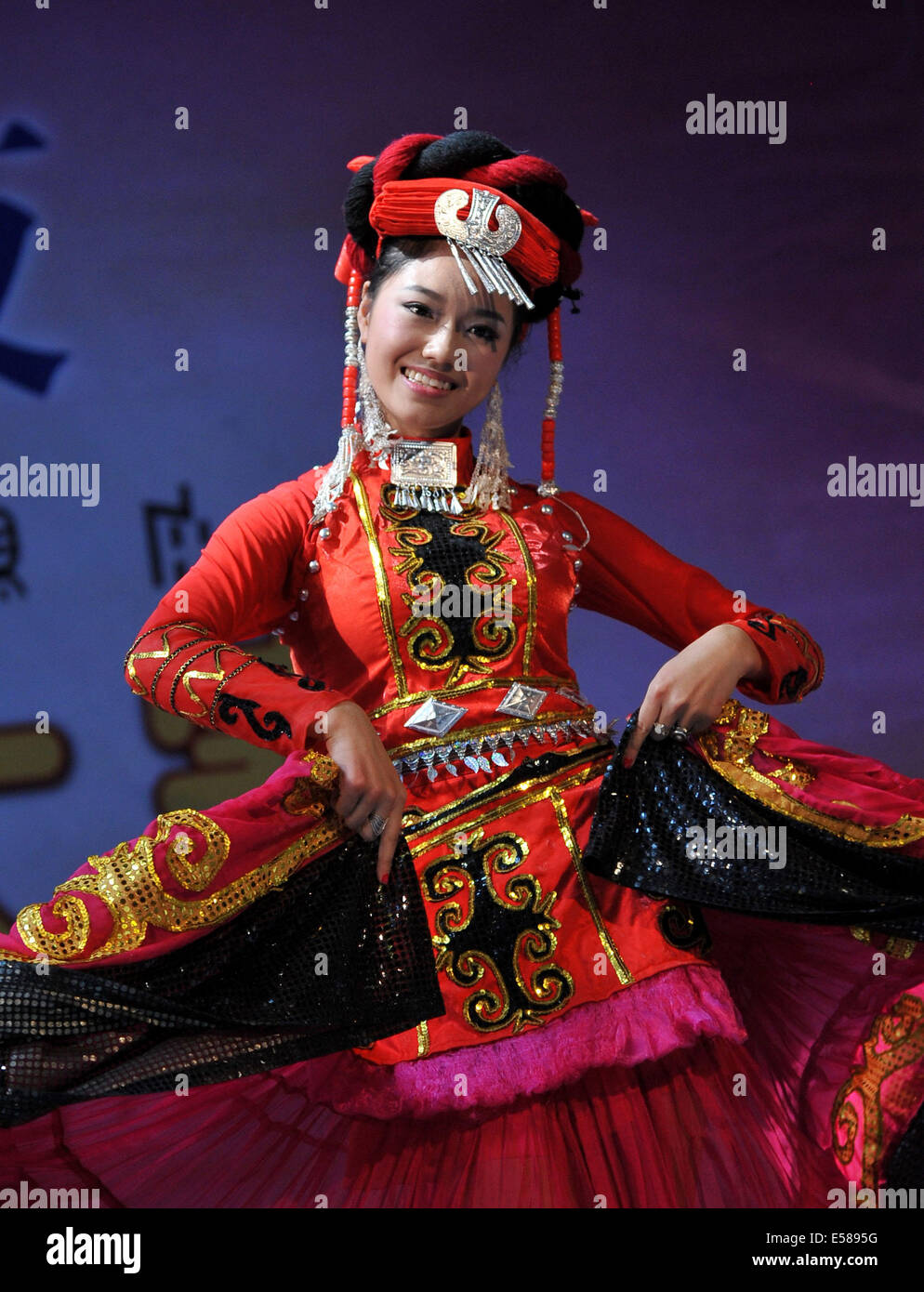 Chengdu, province chinoise du Sichuan. 23 juillet, 2014. Une femme de l'ethnie Yi effectue au cours d'un spectacle de talents d'un traditionnel concours de beauté à Chengdu City, dans le sud-ouest de la province chinoise du Sichuan, le 23 juillet 2014. Le concours de beauté est une des activités les plus importantes au cours de l'assemblée annuelle du Festival de la flamme à Ürümqi Yi Préfecture autonome. Il peut remonter à plus de 1 000 ans dans l'histoire de l'ethnie Yi. © Xue Yubin/Xinhua/Alamy Live News Banque D'Images