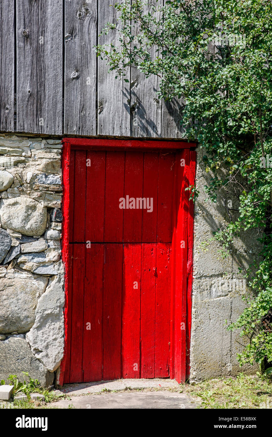 Rouge pompier porte à une vieille grange dans les régions rurales de l'Ontario;Canada ; porte rouge Banque D'Images