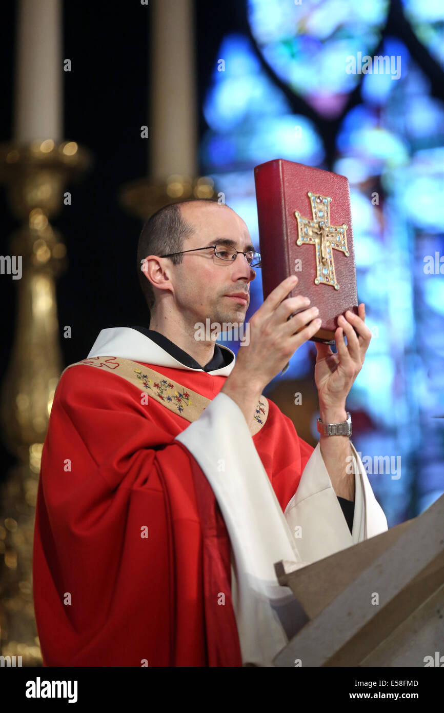 Prêtre catholique, tenant la bible au cours d'un service dans une église catholique de Paris, France Banque D'Images