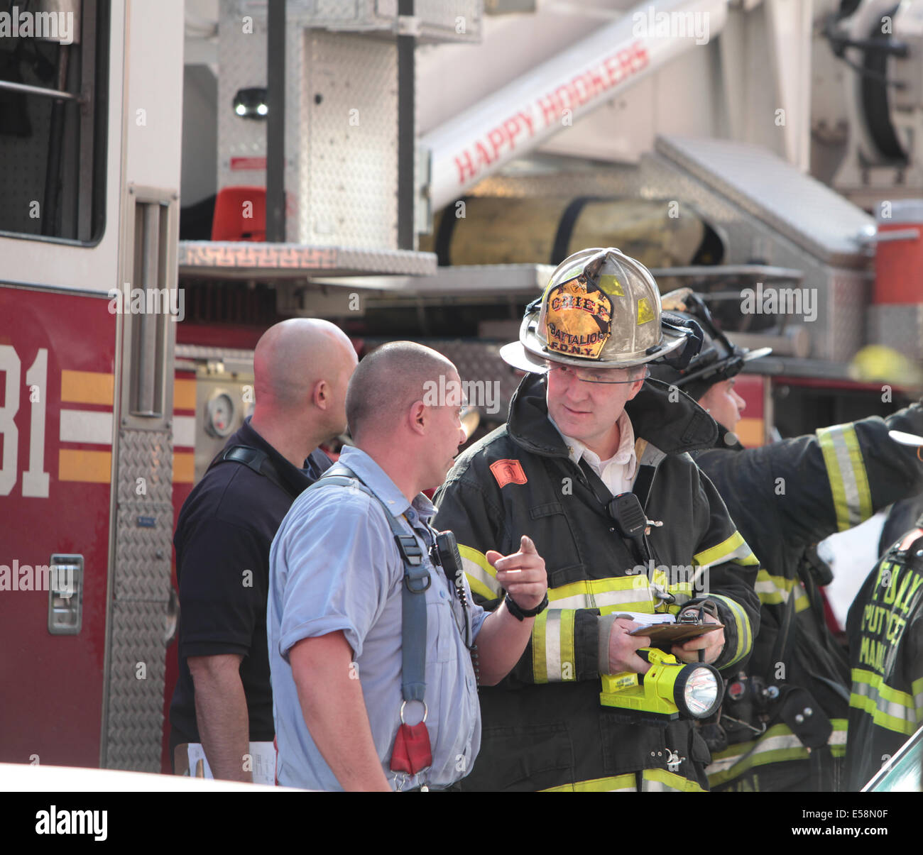 FDNY chef confère avec d'autres pompiers sur les lieux d'incendie résidentiel à Brooklyn près de Gowanus à la lumière du jour Banque D'Images