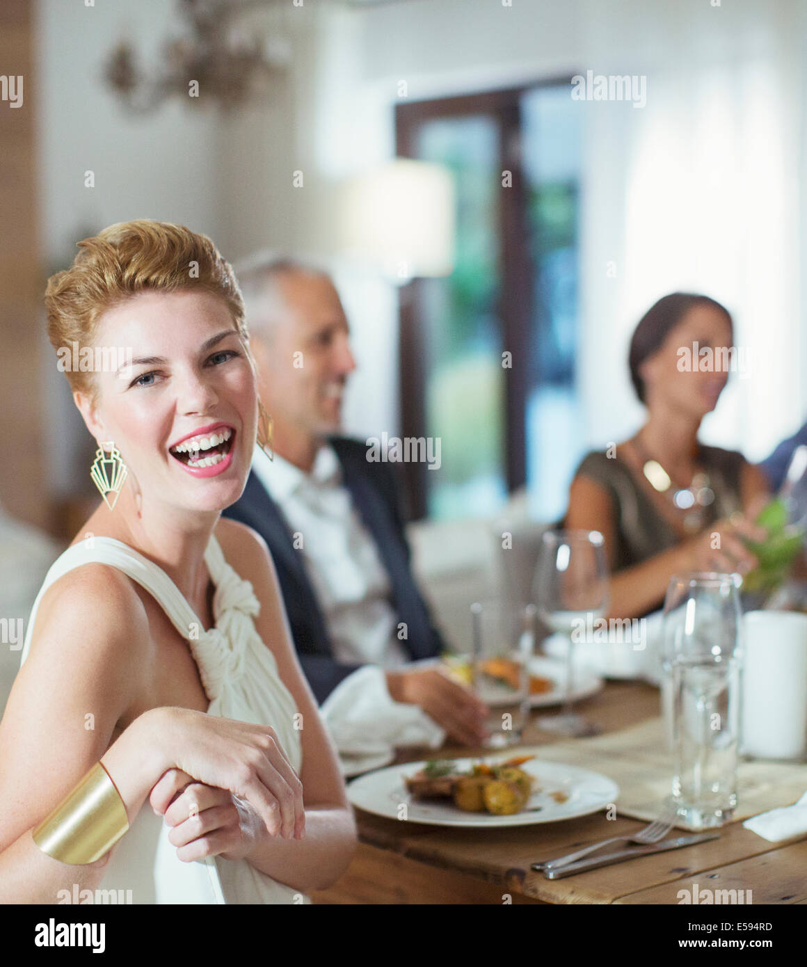 Woman laughing at dinner party Banque D'Images